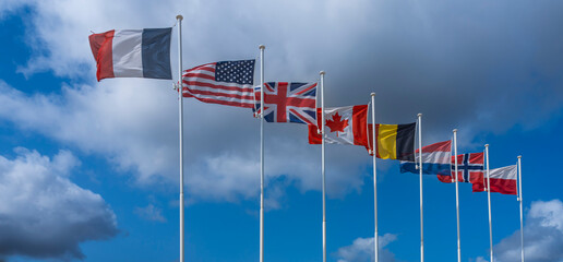 Langrune-Sur-Mer, France - 08 05 2025: Alignment of national flags of the Allies of the Second World War along the beach