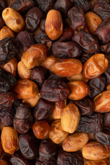 Dried sweet large dates of different varieties close-up top view. Natural sweetness, healthy dessert. Dates texture, food background