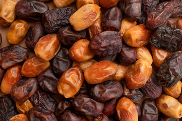 Dried sweet large dates of different varieties close-up top view. Natural sweetness, healthy dessert. Dates texture, food background