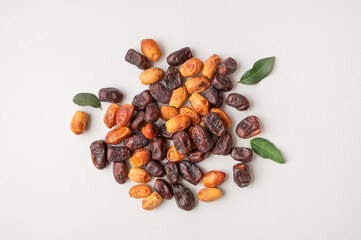 Delicious dried dates of different varieties scattered on gray background flat lay top view. Sweet oriental organic dessert, date palm fruit, healthy snack. Food background