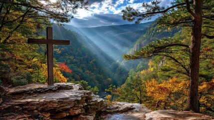 A serene landscape featuring a wooden cross overlooking a valley with rays of sunlight piercing through the trees, showcasing autumn foliage.