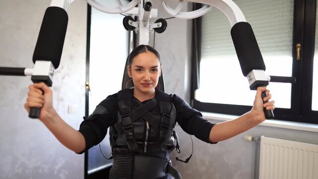 Woman exercising arms with ems suit