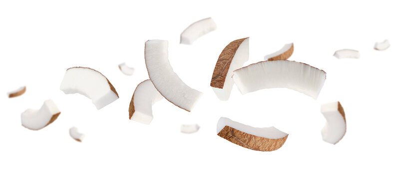 Thin semicircular slices of coconut fly and levitate in space. Isolated on white