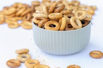 Freshly baked mini bagels on a dark background. Top view. Pretzels in the form of a ring close-up. Small bread circle biscuit. Bowls with different types of bagels.