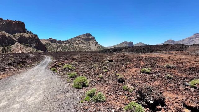 Come explore this stunning volcanic landscape that features a winding path leading to majestic peaks nearby