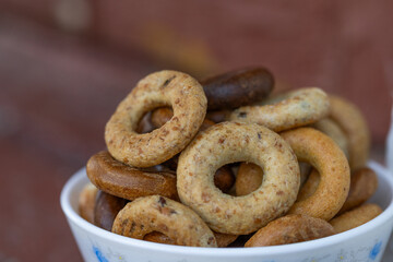 Freshly baked mini bagels on a dark background. Top view. Pretzels in the form of a ring close-up. Small bread circle biscuit. Bowls with different types of bagels.