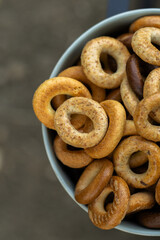 Freshly baked mini bagels on a dark background. Top view. Pretzels in the form of a ring close-up. Small bread circle biscuit. Bowls with different types of bagels.