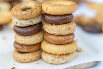 Freshly baked mini bagels on a dark background. Top view. Pretzels in the form of a ring close-up. Small bread circle biscuit. Bowls with different types of bagels.
