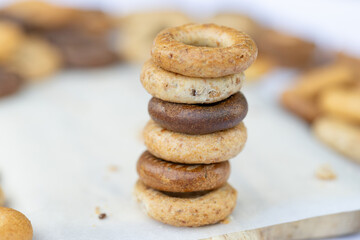 Freshly baked mini bagels on a dark background. Top view. Pretzels in the form of a ring close-up. Small bread circle biscuit. Bowls with different types of bagels.