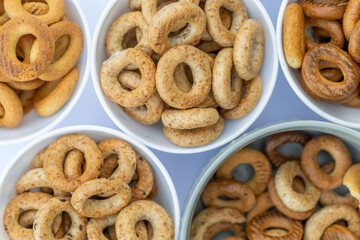 Freshly baked mini bagels on a dark background. Top view. Pretzels in the form of a ring close-up. Small bread circle biscuit. Bowls with different types of bagels.