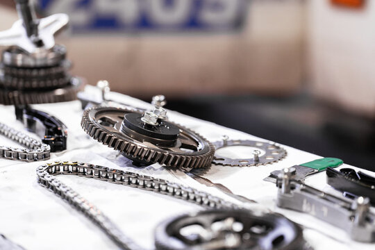 Mechanical components gears and chains arranged on a surface during engine repair