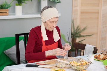 Elderly woman preparing fruit salad at home in the living room