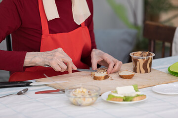 Elderly woman preparing a butter sandwich