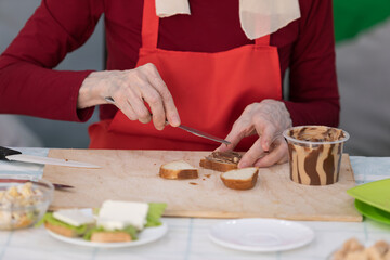 Elderly woman preparing fruit salad at home in the living room