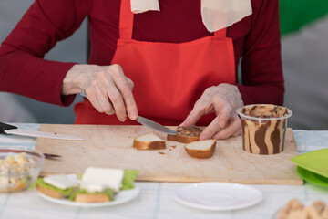 Elderly woman preparing fruit salad at home in the living room