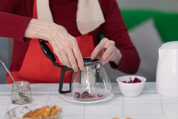 Elderly woman preparing fruit salad at home in the living room