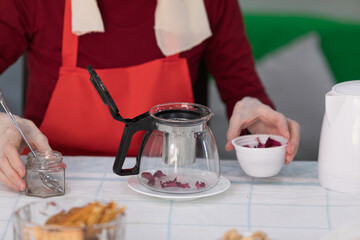 Elderly woman preparing a tea at home in the living room