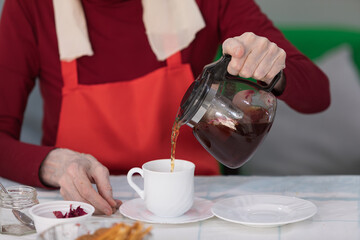 Elderly woman preparing fruit salad at home in the living room