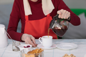 Elderly woman preparing fruit salad at home in the living room