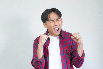 A young man expresses extreme joy and excitement, clenching fists.