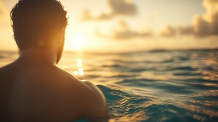 Fototapeta premium Man enjoys sunset while swimming in calm ocean waters at dusk