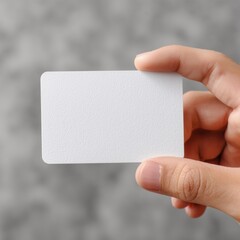 Hand Holding Blank White Business Card – Close-Up with Rounded Corners and Gray Blurred Background