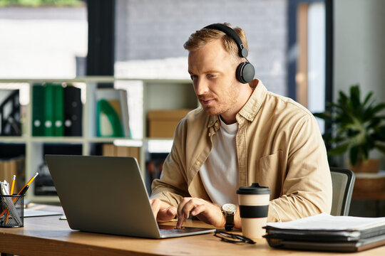 Focused young businessman working diligently in modern office environment with laptop