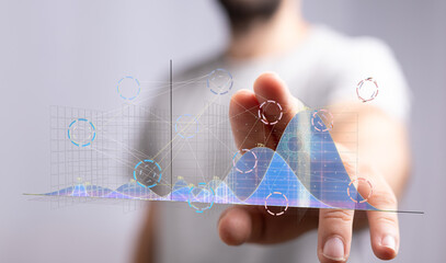 A businessman interacts with a holographic projection of data graphs and charts, visualizing business analytics and insights.