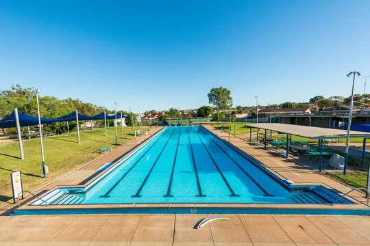 Long outdoor swimming pool with multiple lanes marked for lap swimming