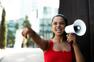 Woman in red outfit shouting with megaphone during urban protest