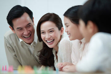 Fototapeta premium joyful family gathering around tabletop game laughter filling room as people share lighthearted moments
