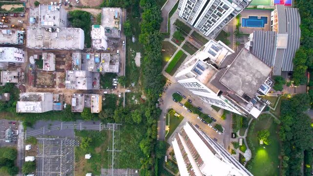 Aerial drone shot straight down at skyscrapers, gardens, sports areas, pools of an upmarket luxurious residential condominium by Tata showing development in real estate