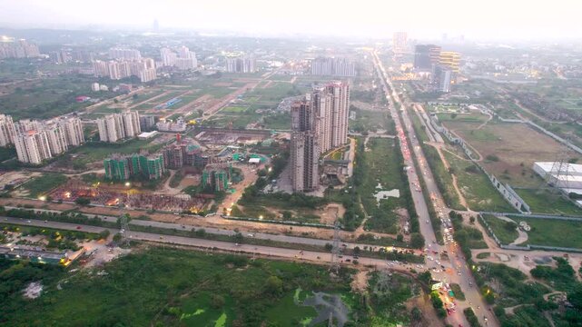 Aerial drone shot locked on under construction buildings showing development of real estate projects around busy roads like southern peripheral road gurgaon