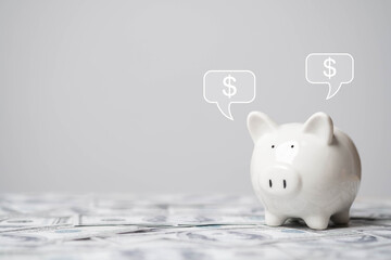 A white piggy bank sits on dollar bills with dollar signs in speech bubbles above it, symbolizing saving money and financial planning.