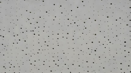 Perforated acoustic ceiling tile with small holes creates a modern and minimalist textured background design.