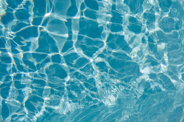 High-resolution photo of a blue pool's surface with light reflections. Perfect for summer, vacation, and relaxation themes.