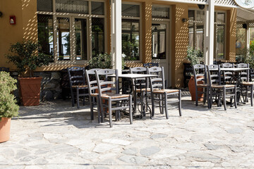 Stock photo of empty tables and chairs on a sunny patio outside a restaurant. Perfect for restaurant, cafe, or travel themes.