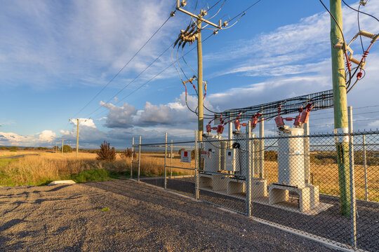 A roadside electrical substation and transformer behind a fence
