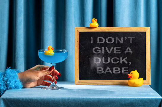 Woman with cocktail and rubber ducks by ironic relationship message