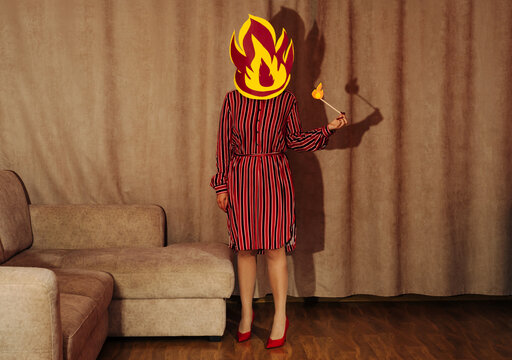 Woman in retro style standing in living room with fire head symbolizing burnout