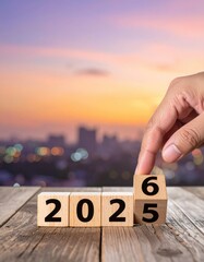 hand flipping block 2025 to 2026 text on table 