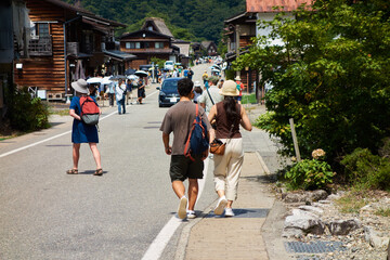 夏の観光名所世界遺産の白川郷の合掌造りと観光客の姿
