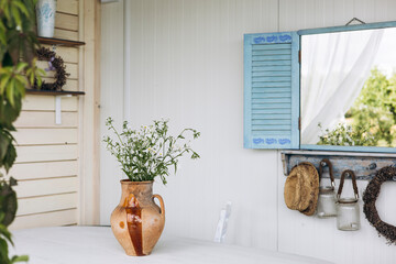 Mirror designed as window with blue shutters hanging on wall, rustic home decor.