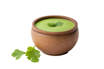 Fresh green sauce in a wooden bowl garnished with cilantro leaves, isolated on a white background.