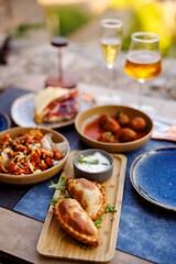 Spanish Tapas with Empanadas, Meatballs, Cheese and Drinks on a Rustic Table