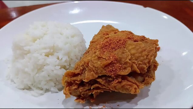 Fried rice and chicken sprinkled with chili powder