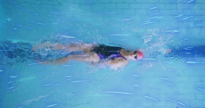 Female lap swimmer entering lane, initiating front crawl over stripe flutter kicking for fitness