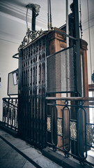 Well-preserved antique elevator inside historic building, featuring intricate wrought iron gates, wooden paneling and vertical lifting mechanisms © Philipp Berezhnoy