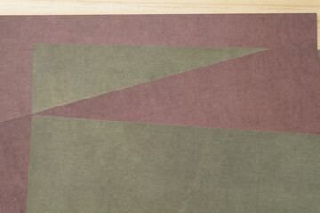deep burgundy and moss green scrapbook paper edges layered on a wooden surface