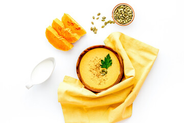 Pumpkin soup - with parsley and seeds - on white background top view
